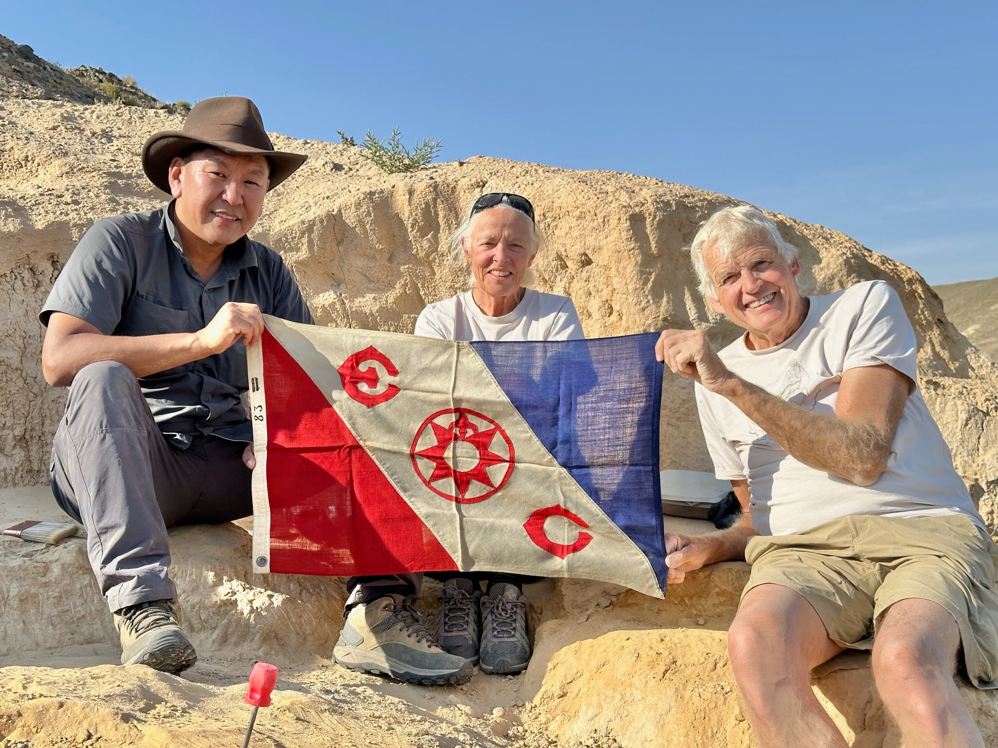 Mongolia Quest's ceo Gereltuv Dashdoorov holding the Explorers Club flag with Dr.Phil Currie and Dr. Eva Koppelhus on the Flag expedition in the gobi desert, 2025. 