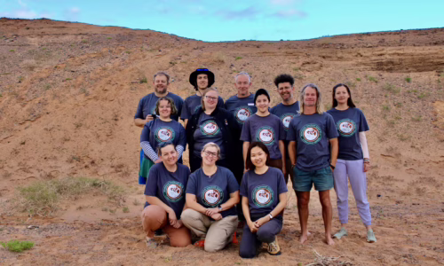 Group photo of Mongolia Quest 2024 Paleontology Expedition participants, all wearing matching t-shirts featuring the expedition logo.