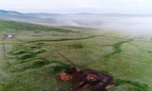 Xianbei tomb site in Orkhon Aerial shot of archeological digging site for ancient tomb that dates back Xianbei period on a green steppe with Mongolian ge in a background, in Orkhon soum in Selenge province.