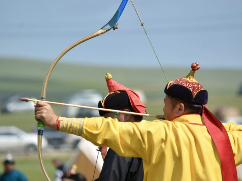 Mongolian Traditional Archery athlete ready to release the arrow. Archery competition at Naadam Festival, Mongolia