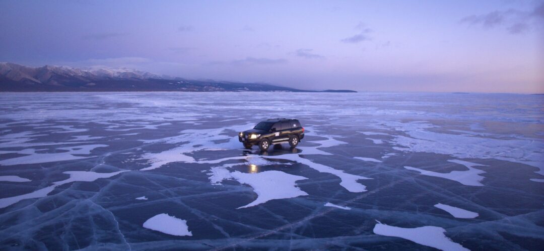 LC on frozen Khovsgol Car driving across frozen Lake Khovsgol at dawn during a winter trip in Mongolia